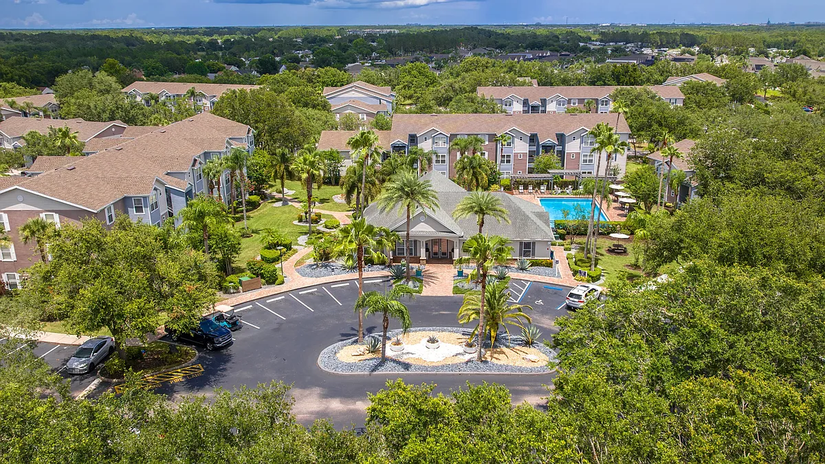 Discover the lush, resort-style layout of Ashton Chase Apartmentsfeaturing vibrant landscaping, a sparkling pool, and spacious apartment homes. - Ashton Chase