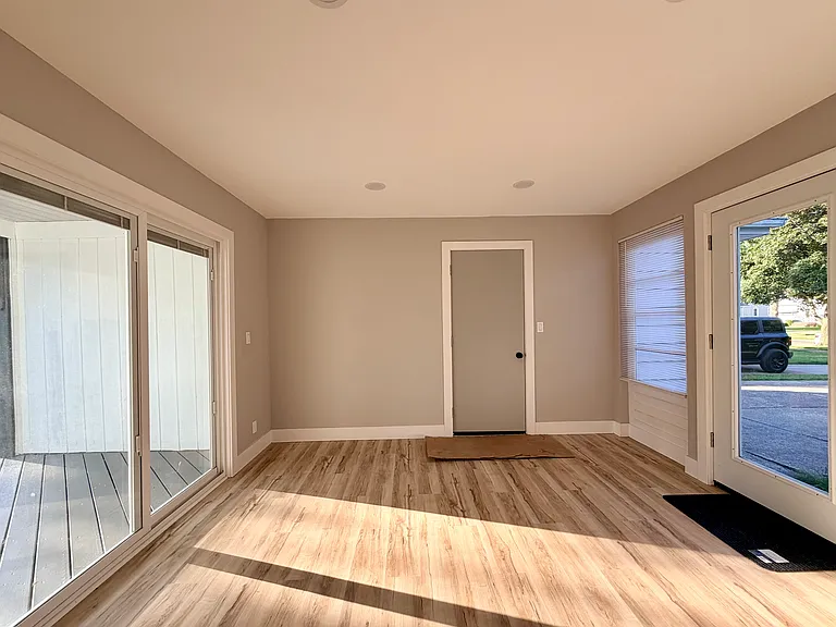 Bright sunroom / Florida room with direct access to the large wooden deck and backyard. Secondary entrance between garage and main house
