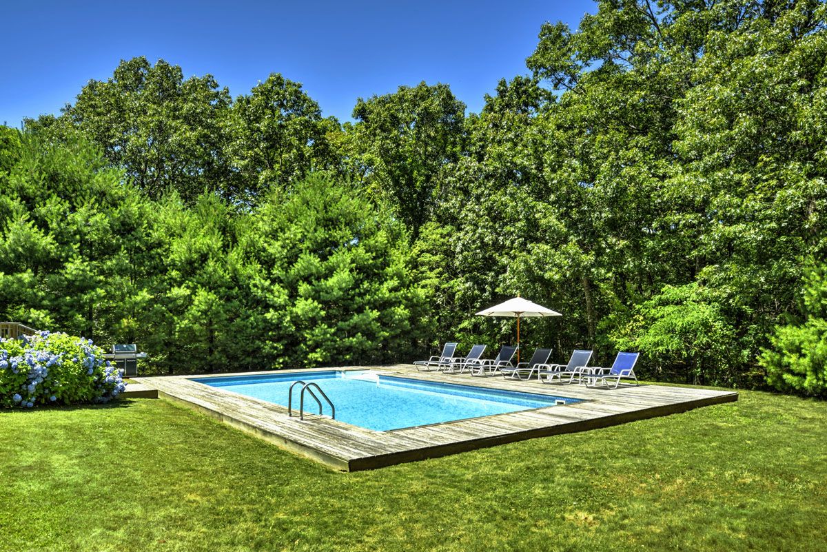  Sunny pool with cedar deck and private backyard surrounded by mature pine trees
