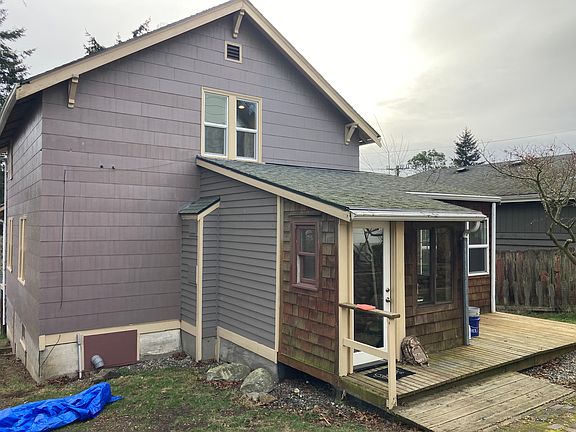 Back of house showing deck and private, landscaped yard