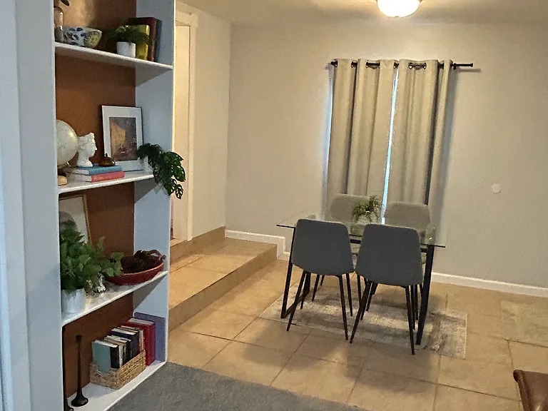 DINING AREA ADJOINS THE REC ROOM, WITH A BUILT-IN BOOKSELF.