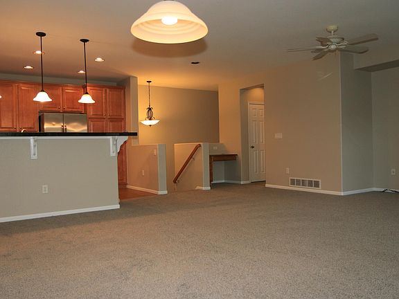 View from dining area to kitchen, entry stairs, desk, and hallway to laundry and second bedroom