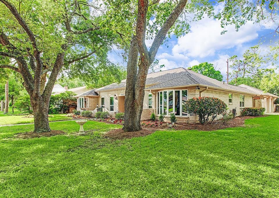 Side view shows the garden and more oaks. The shrubs include red tip photenia, roses and gardenia bushes surrounded by seasonal 