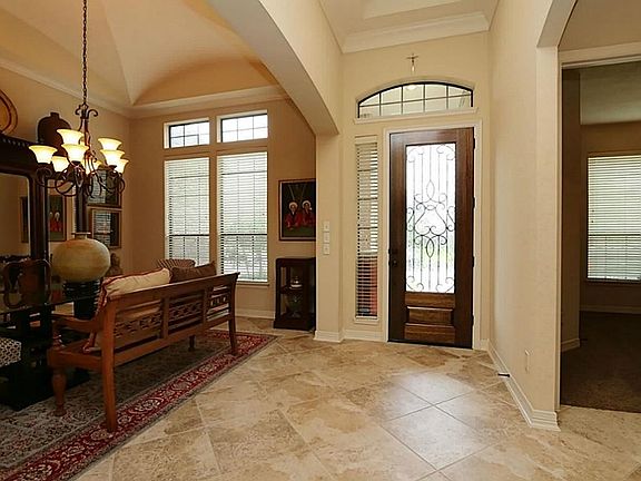The dramatic entry features a beautiful leaded glass front door with side light and transom windows 