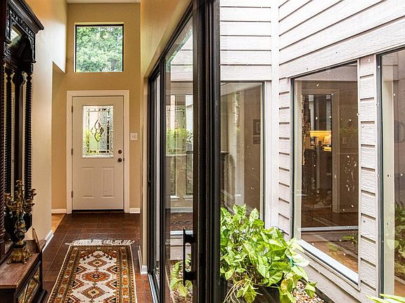 Light filled entry and nicely landscaped atrium. Secondary bedrooms and bathroom are to the left. Dining room and kitchen to the right.