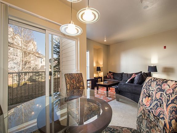 Combination livingroom and dining area with artistic chandeliers. Sliding glass door on left to patio.