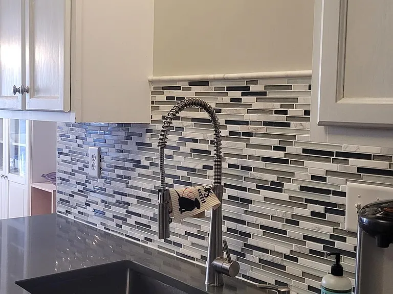 Quartz counter tops and trendy pull down industrial faucet.
