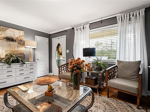 Living room featuring ornamental molding and wood-type flooring