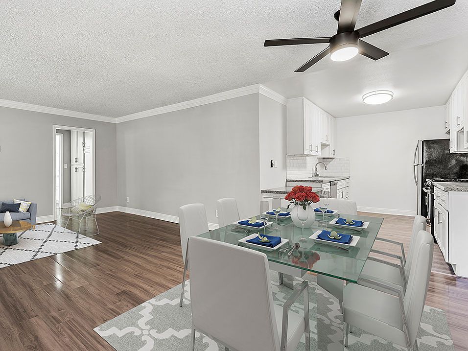 Large hardwood floored dining room with view of kitchen.