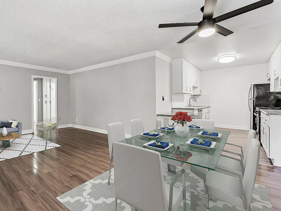 Large hardwood floored dining room with view of kitchen.