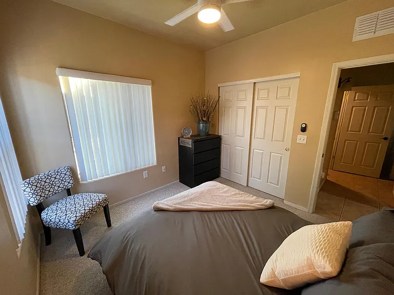Bedroom 2 with neutral carpet and walls and closet