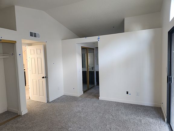 Master bedroom downstairs with high vaulted ceilings, new paint throughout and new carpet.
