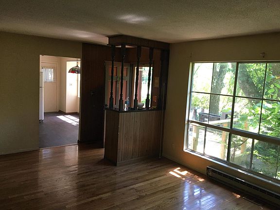 Large windows in living area. Front entry located between kitchen and living room faces dining room