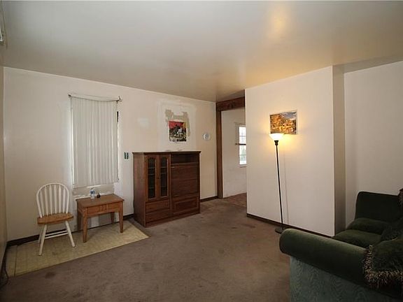 14x13 Living Room with framed Entryway, 2 Double Pane Windows, and Carpet and Vinyl flooring.