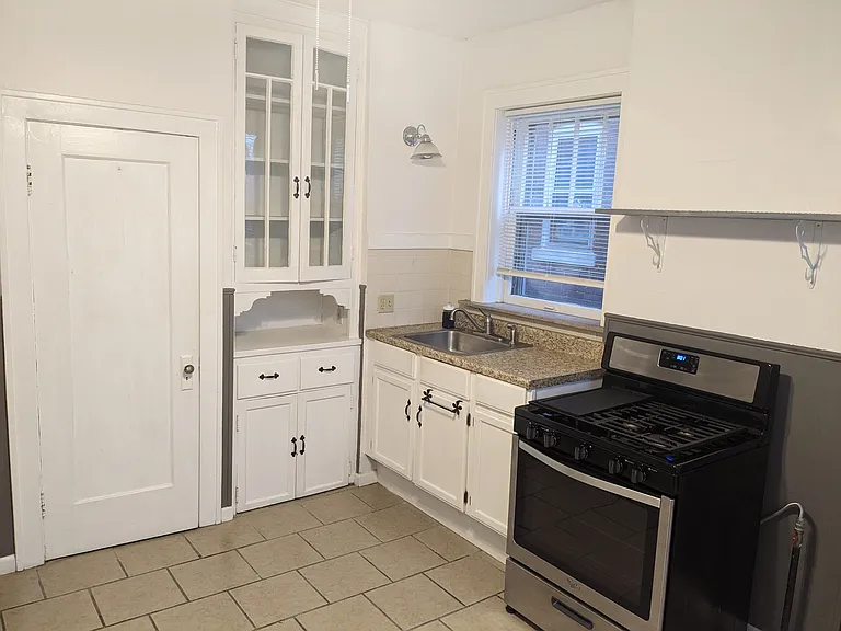 The kitchen has updated appliances (Stove, refrigerator, microwave) as well as a full pantry and custom built-in cabinets.