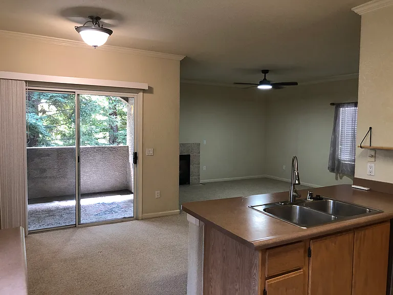 View of living area and dinning room from Kitchen. Sliding glass entrance to Patio.