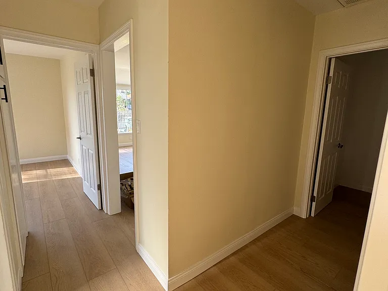 Hallway from bedroom #1 and living room. Storage room on the right.