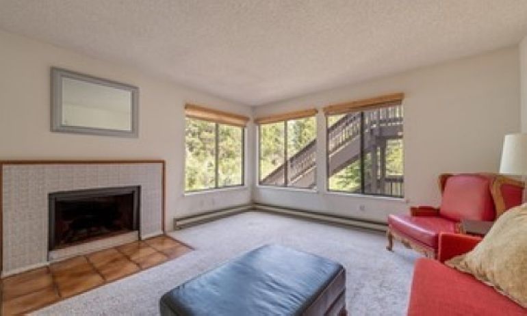 Open and light, semi-furnished living room, with creek views.