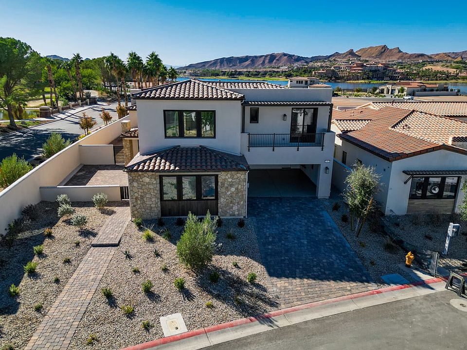 A modern, multi-story residential building with a tiled roof sits atop a landscaped courtyard, surro