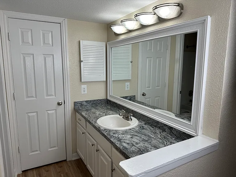 Elegant bathroom with sleek modern countertop, spacious mirror, and stylish lighting, offering a bright and fresh ambiance. Elegant bathroom with sleek modern countertop, spacious mirror, and stylish lighting, offering a bright and fresh ambiance.