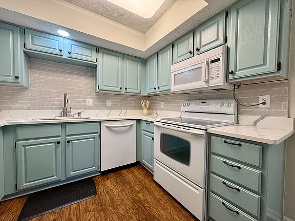 New stone countertops and freshly painted cabinets.