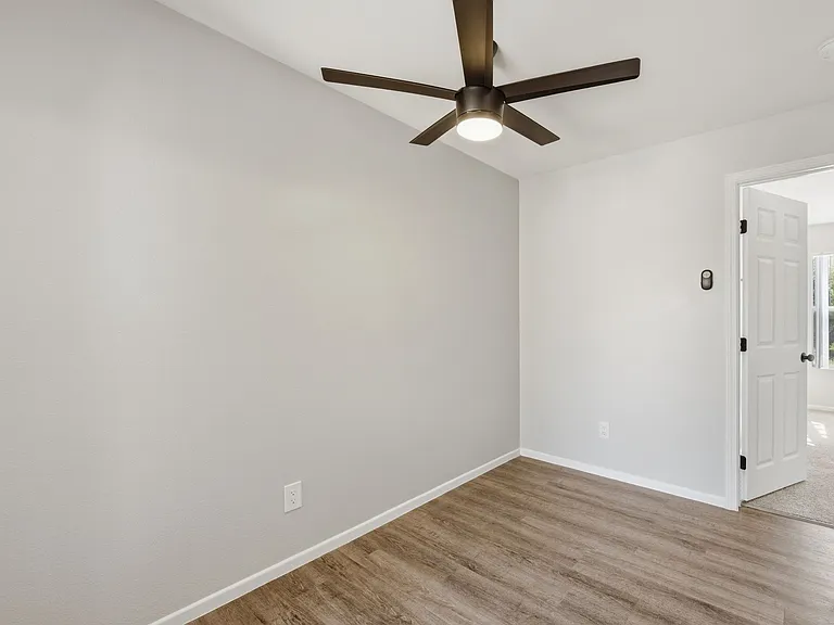 A room with a ceiling fan and light fixture.
