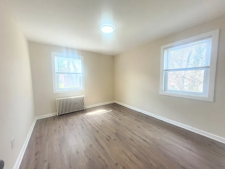 Large bedroom with natural light and room for a queen sized bed.