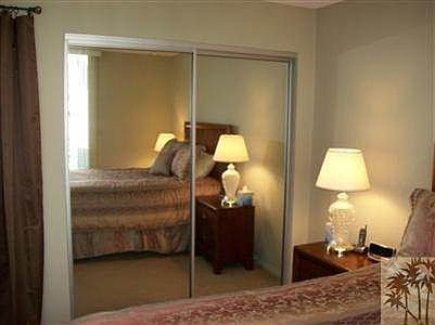Master bedroom suite has large mirrored doors on closet.