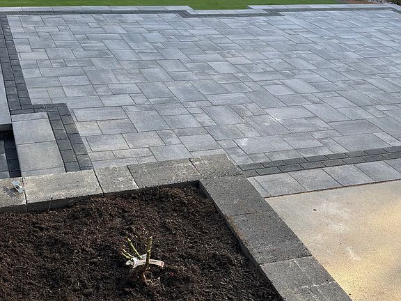 Smell the rose bush next to the covered patio and large entertaining patio.