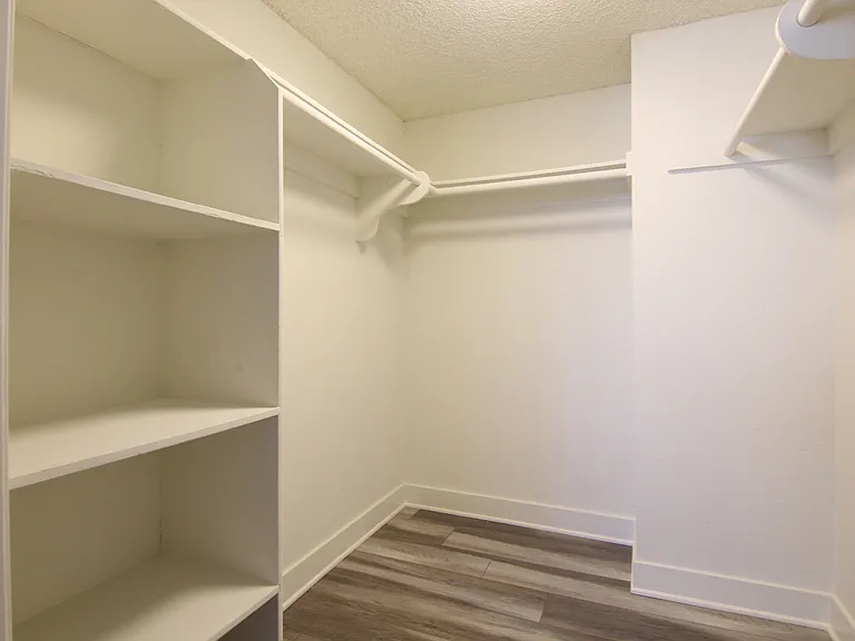 Walk in closet with ample storage, shelves, and hanging rods.