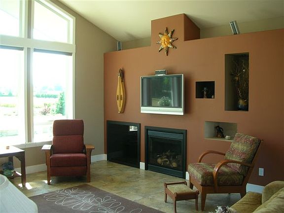 The great room design focuses on the panoramic view of the Olympic Mountains through the dramatic wi