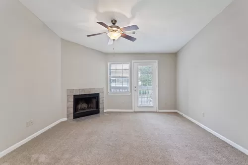 Living Room with Private Patio Access - Villages at Spring Hill Apartments