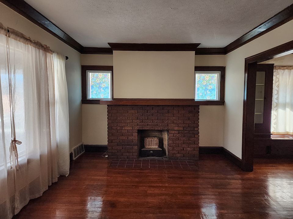 Bright and cozy living room with hardwood floors and decorative fireplace