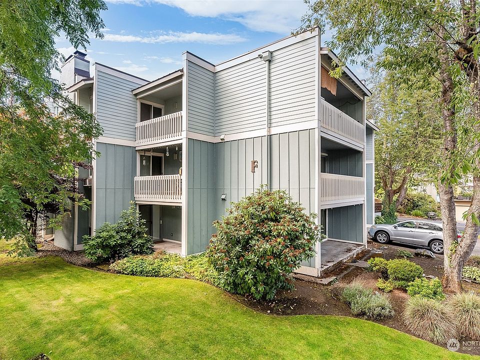 Welcome to Building F at 7425 Ruby Dr SW in Lakewood! This photo is taken from the lower parking lot. See the stairs on the left side of this photo? Take them up to the building's middle level. That's where you'll find the lobby entry for this unit.>