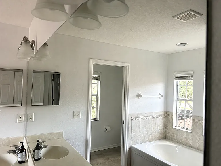 Master bath mirror covers almost the entire bathroom.