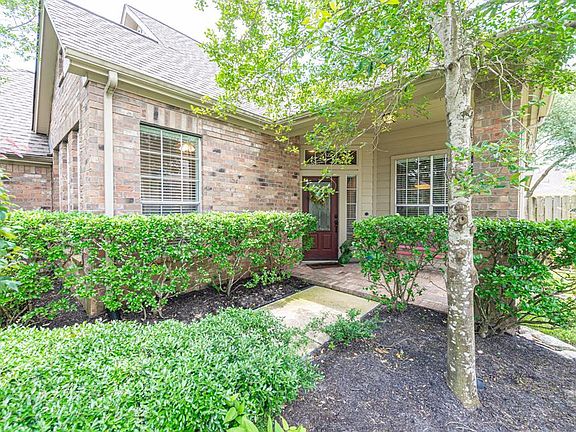 Lush landscaping escorts you to the bricked front porch--giving you a hint of the treasures you will find inside!