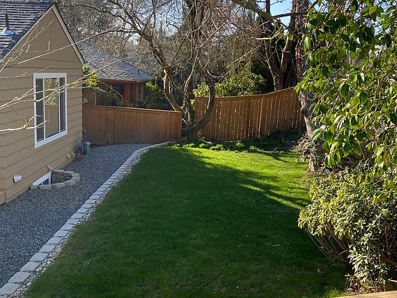 Front yard. Beautiful landscaping, grass and partially fenced.