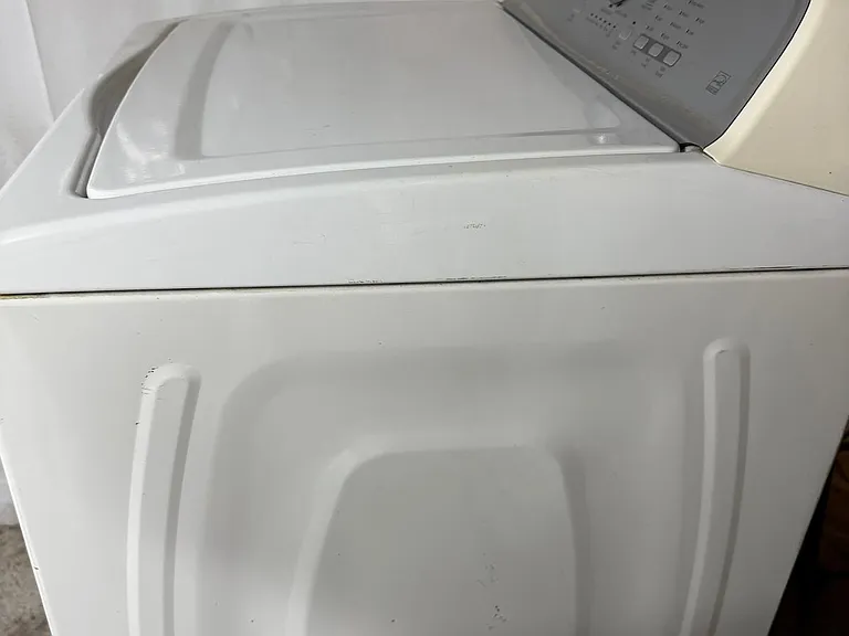 Dedicated laundry area with a top-load washing machine for convenient on-site laundry access.