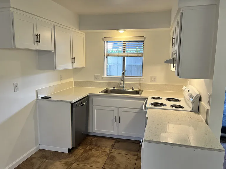 Nice white kitchen features d/w, Quartz counter tops, updated shaker cabinet doors with contemporary pulls, new range hood, extra 'floating' cabinet on wheels. Really nice