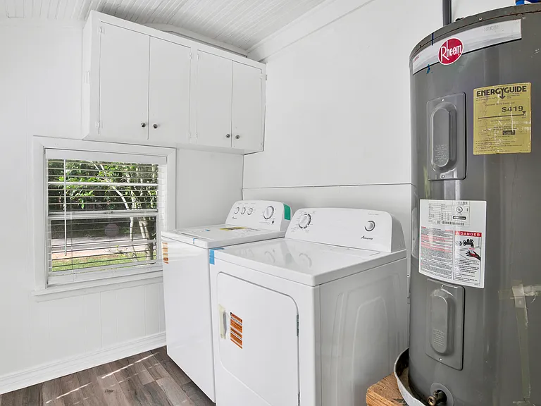 New washer dryer in laundry room with cabinets.