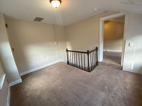 Living room with stairs to first floor and step up entrance to bedroom
