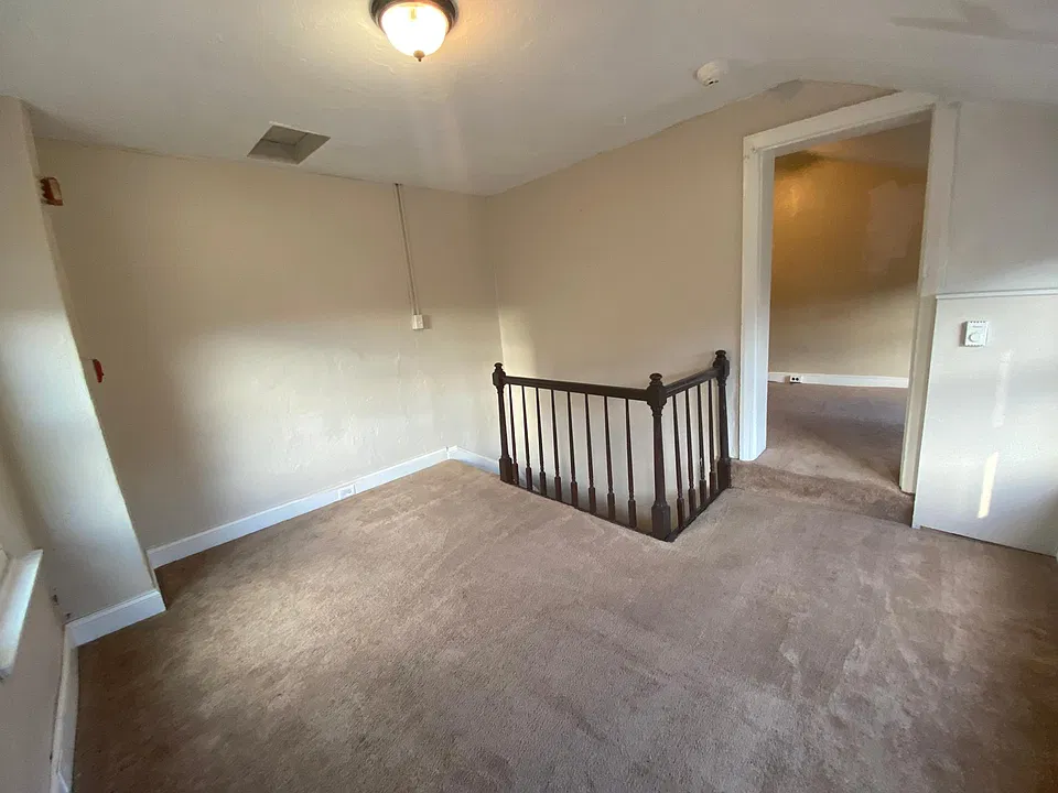 Living room with stairs to first floor and step up entrance to bedroom