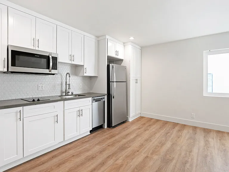 Studio Apartment Kitchen including Two-Burner Stovetop,Dishwasher, Full-Size Refrigerator, Microwave, and Plenty of Cabinet Storage