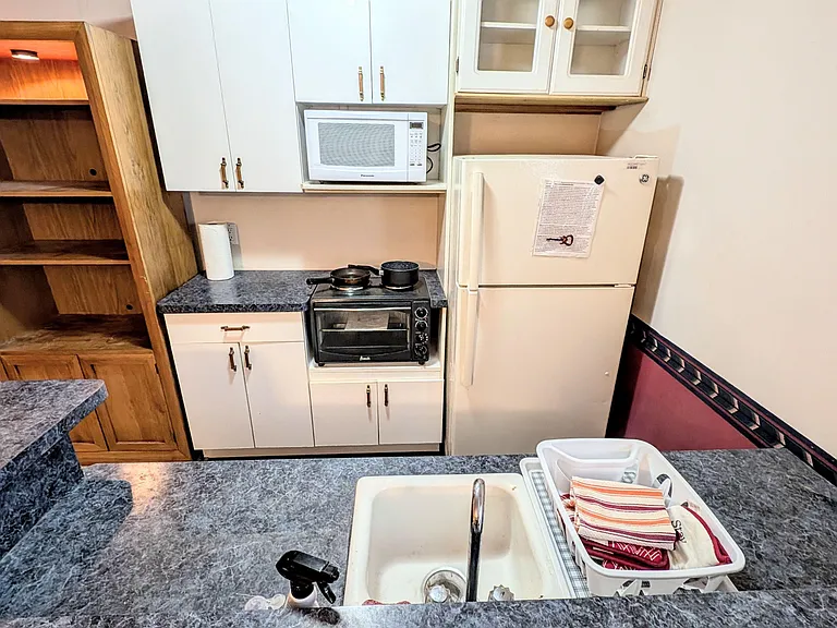 Efficient kitchen with ample cabinet storage, full-size refrigerator, and generous counters with an integrated sink.