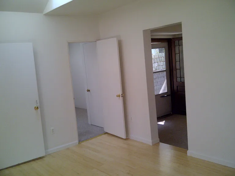 Living room looking toward bedroom and den with back door to private patio