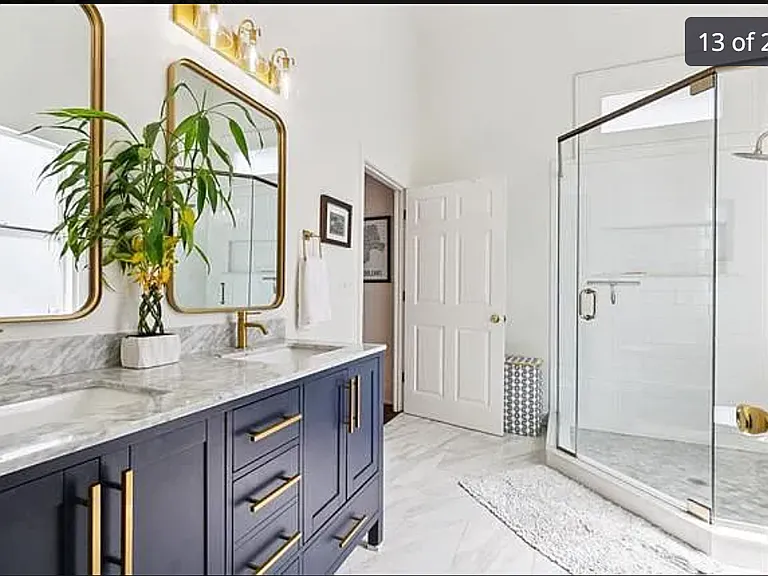 modern, light filled bathroom with two sinks and a huge shower