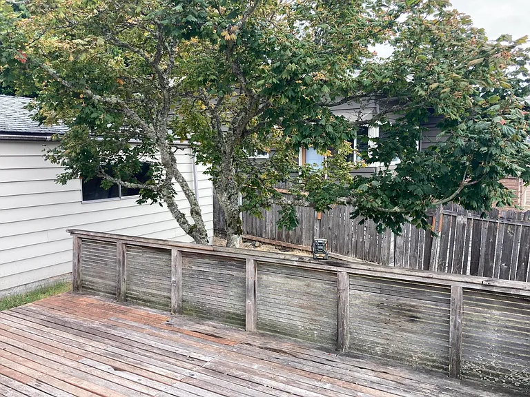 Deck, garage is on left of photo. Garage equipped with power, lighting, workbench, shelving, storage. Garage door is new, easy lift. Plenty of room for both one car and work area.