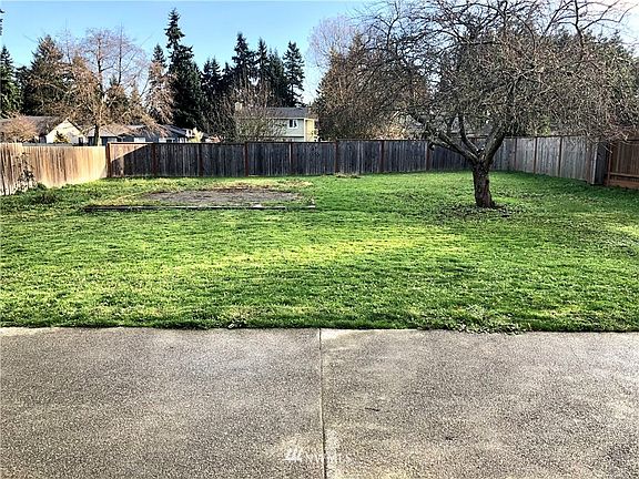 Concrete patio right off of kitchen with a sliding glass door.