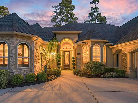 Meticulous landscaping surrounds the front walkway to the covered front porch. Notice the over-sized two car garage with golf cart parking. All bronze statues in front yard are negotiable.