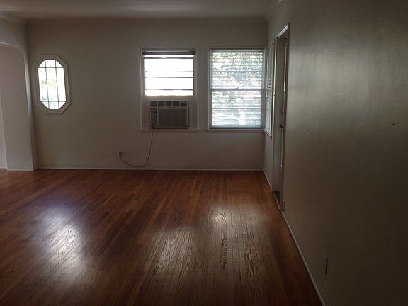 spacious living room with wall air unit & french door to pri